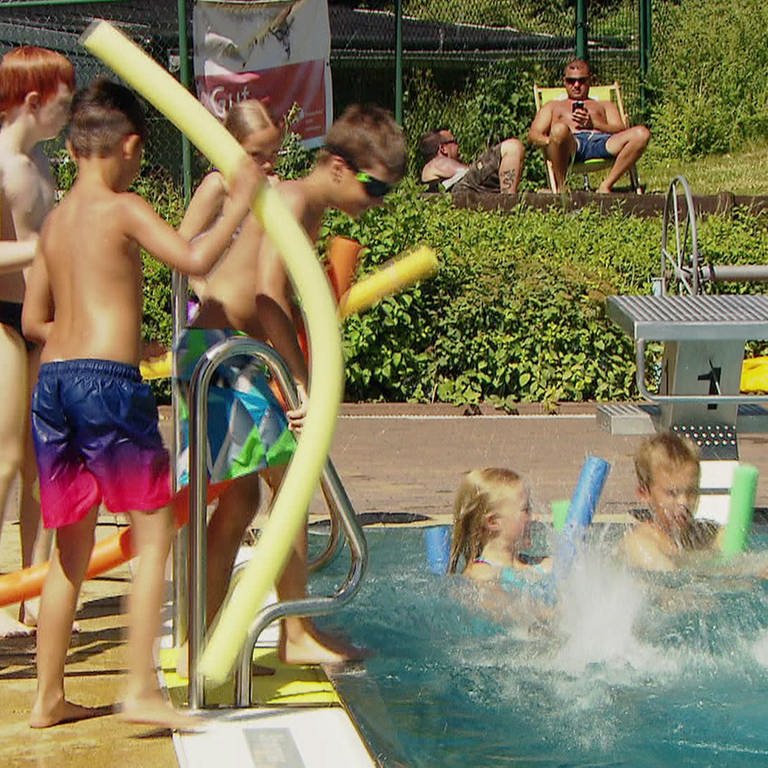 Kinder im Schwimmbad am Beckenrand und im Wasser (Foto: SWR)