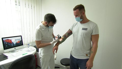 Dr. Uwe Kirschner – Hautarzt aus Mainz - untersucht tätowierten Patienten in seiner Praxis (Foto: SWR)