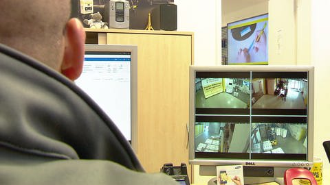 Mitarbeiter beobachtet Monitor mit Kamerabildern der Videoüberwachung im Mainzer Mietlager. (Foto: SWR)