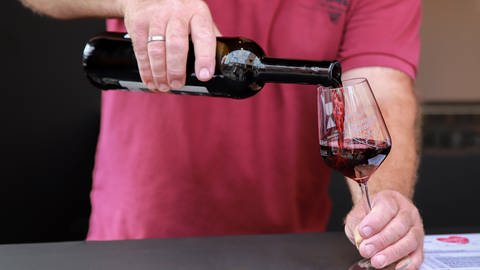 Mann schenkt Wein ein - Fettleber vermeiden