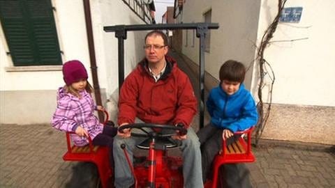 Vater mit zwei Kindern mit dem Traktor unterwegs (Foto: SWR, SWR -)