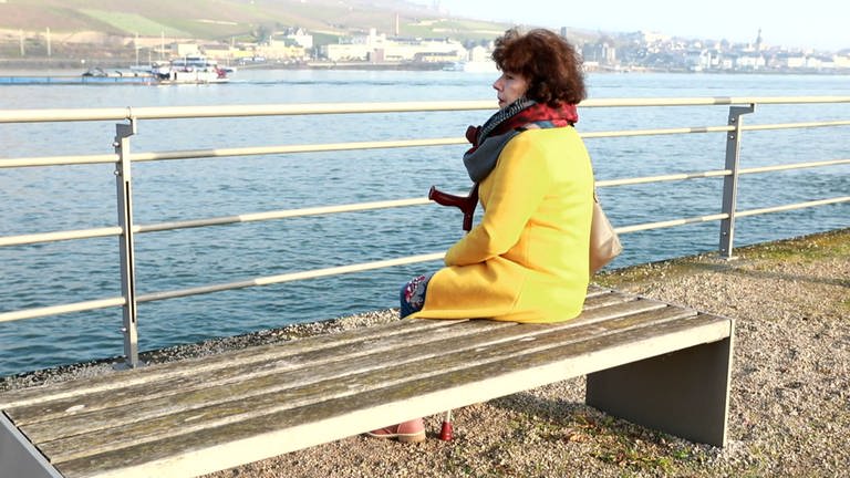 Pia Bauer sitzt nachdenklich am Rhein in Bingen: 2018 beging ihr Sohn Dirk Selbstmord. (Foto: SWR)