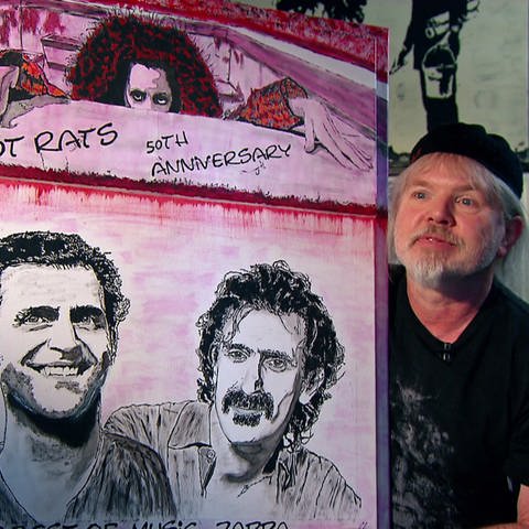 Engelbert Hölper mit einem Porträt von Frank Zappa und dessen Sohn Dweezil