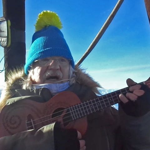 Liedermacher und Friedensaktivist Uli Valnion spielt Gitarre in einer Berggondel