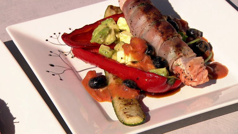 Lachs im Baconmantel mit frischem Koriander, Avocado mit Feta als Salat und geschmortes Gemüse mit Buttermilch-Tomaten-Ruccola-Blaubeer-Sauce.   (Foto: SWR)