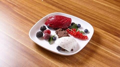 Mohn-Joghurt-Mousse Schoko-Crumble und Beerensorbet, dekoriert mit Johannesbeeren, Brombeeren, Heidelbeeren und Himbeeren