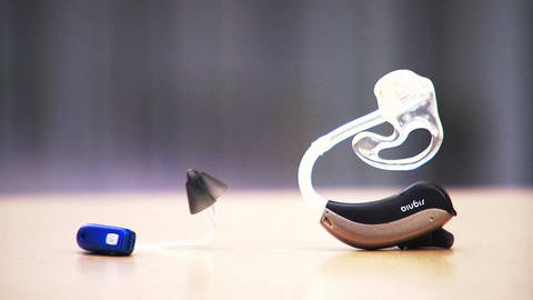 Auf einem Tisch liegt ein Hörgerät, das in mehrere Einzelteile zerlegt worden ist. (Foto: SWR)