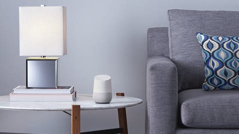Ein Google Home Lautsprecher steht auf einem Beistelltischchen neben einer Lampe (Foto: dpa Bildfunk, picture alliance / -/Google/dpa)