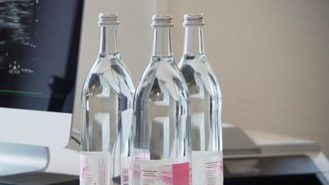 Drei Wasserflaschen aus weißem Glas stehen eng nebeneinander. (Foto: SWR)