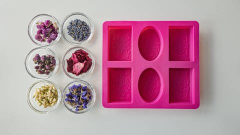 Sechs Glasschalen mit verschiedenen Blütenblättern und eine Silikonform für Seife. (Foto: SWR)