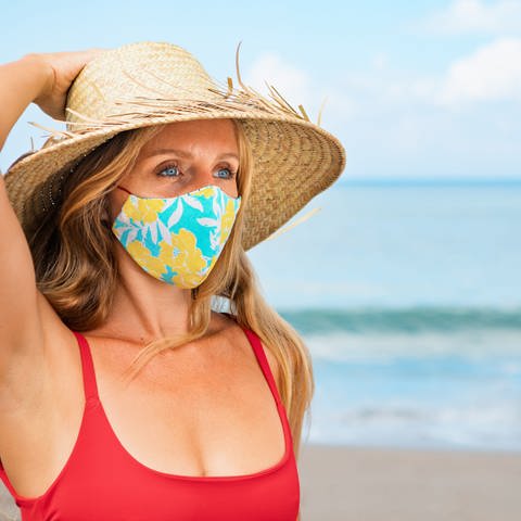 Frau am Strand mit Mund-Nase-Schutz (Foto: Colourbox)
