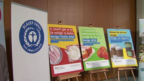 Plakate stehen in einem Raum und weisen auf eine Kampagne des Bundesumweltministerium für weniger Verpackungsmüll hin. (Foto: SWR)