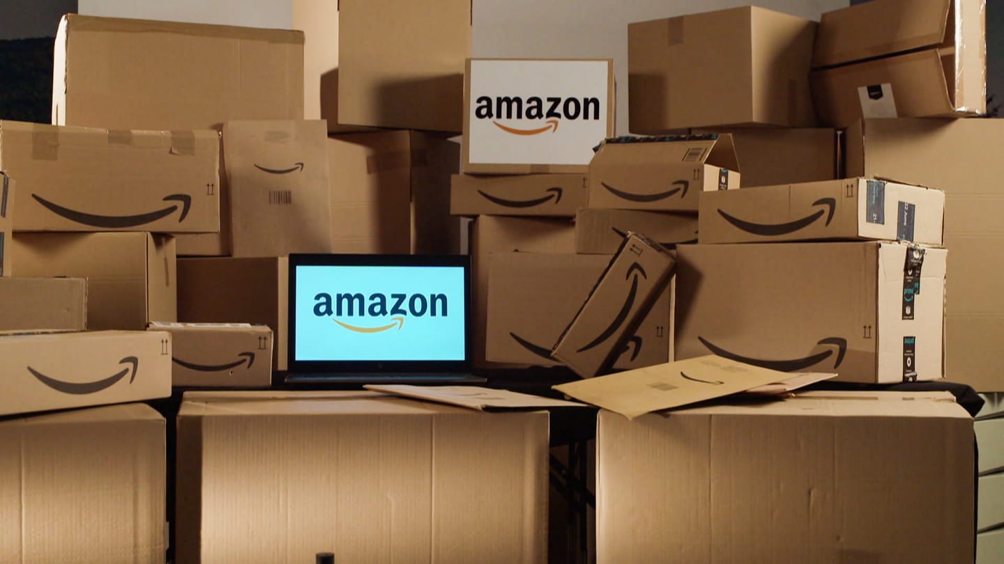 Bildschirm mit Amazon-Logo, drum herum Pakete