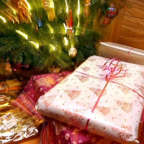 Weihnachtsgeschenke liegen unter einem geschmücktem Christbaum. (Foto: dpa Bildfunk, Picture Alliance)
