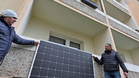 Zwei Männer stehen vor einem Balkonkraftwerk. Diese Mini-PV-Anlagen können viel Solarstrom für den Eigenverbrauch erzeugen. (Foto: dpa Bildfunk, picture alliance/dpa/dpa-Zentralbild | Martin Schutt)