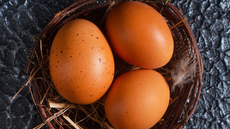 In einem Weidenkörbchen liegen drei braune Eier, davor liegen zwei weitere (Foto: Colourbox, Haivoronska_Y)