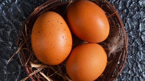 In einem Weidenkörbchen liegen drei braune Eier, davor liegen zwei weitere (Foto: Colourbox, Haivoronska_Y)