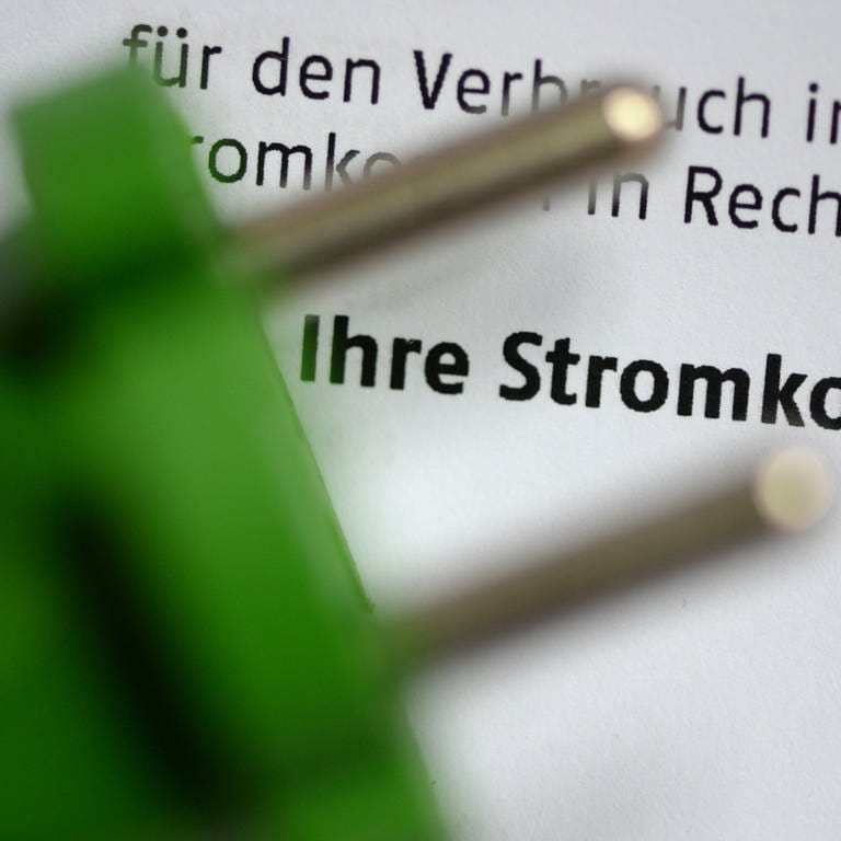 Grüner Stecker vor Stromkostenrechnung. (Foto: picture-alliance / Reportdienste, Picture Alliance)