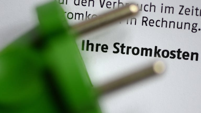 Grüner Stecker vor Stromkostenrechnung. (Foto: picture-alliance / Reportdienste, Picture Alliance)