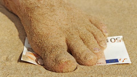 Fuß steht im Sand auf einen 50-Euroschein (Foto: Colourbox)