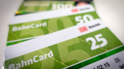 Auf einem Tisch liegen übereinander eine Bahncard 25, eine Bahncard 50 und eine Bahncard 100. (Foto: dpa Bildfunk, Picture Alliance)