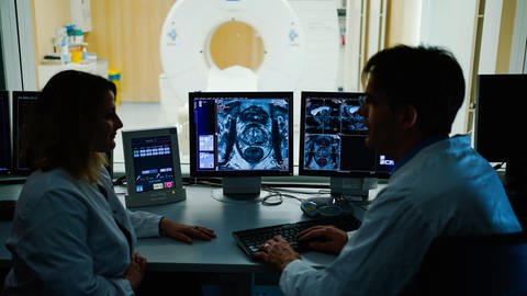  Mitarbeiter betrachten in einem Kontrollraum des Deutschen Krebsforschungszentrum (DKFZ) auf einem Monitor das Querschnittsbild einer Prostata.  (Foto: picture-alliance / Reportdienste, picture alliance/Uwe Anspach/dpa)