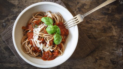 Teller mit Vollkornspaghetti und Tomatensoße mit Mozarella und Basilkumblättern. (Foto: IMAGO, imagoimages)
