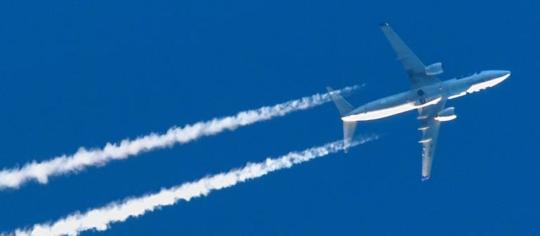 Ein Flugzeug mit Kondensstreifen ist am blauen Himmel zu sehen. (Foto: dpa Bildfunk, picture alliance/Patrick Pleul/dpa-Zentralbild/dpa)