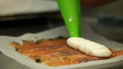 Auf dünn geschnittenden Lachs wird ein Parmesanmousse gespritzt (Foto: SWR)