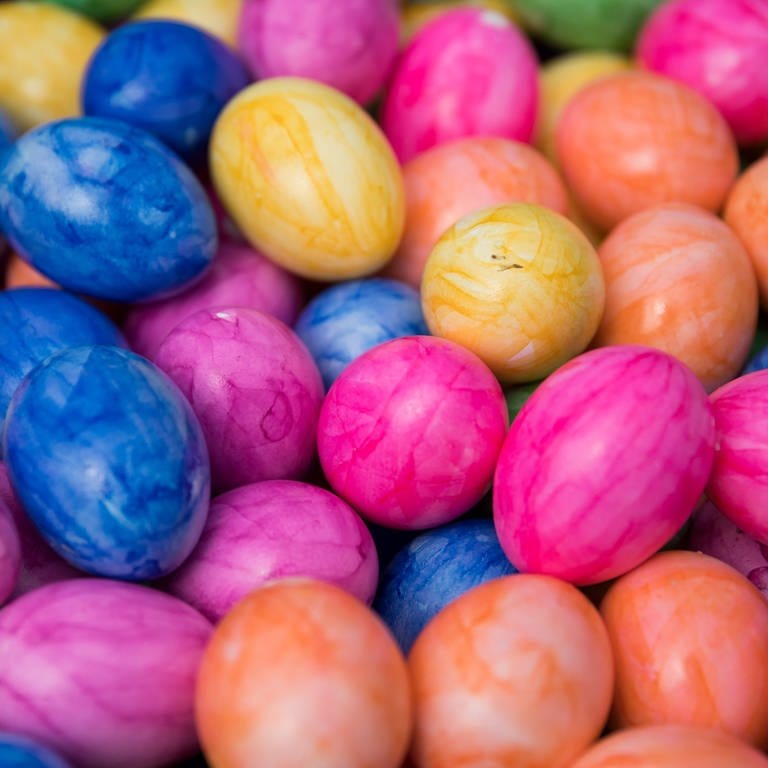Bunt gefärbte, hartgekochte Eier liegen in einem Korb.