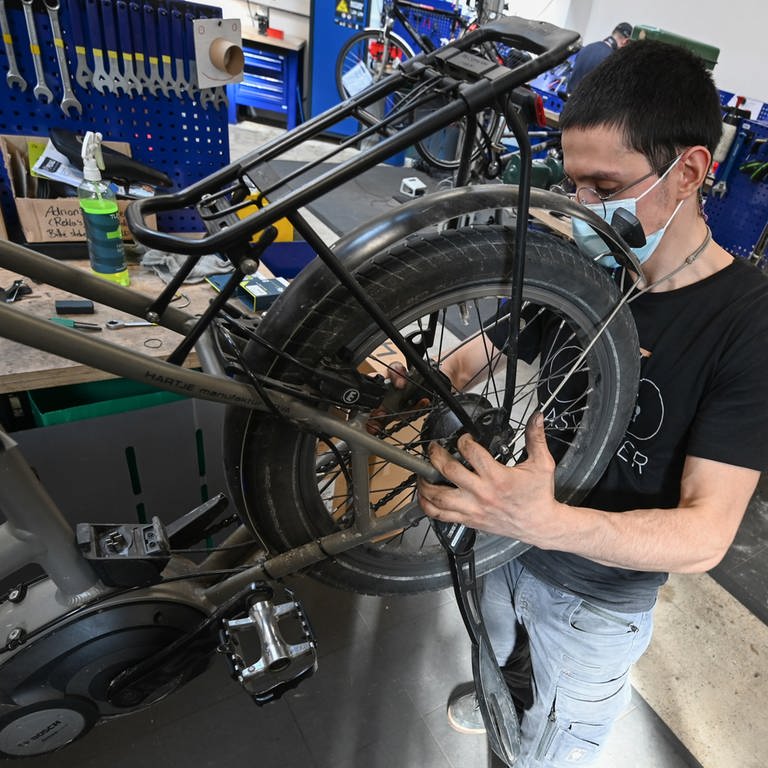 Ein Mechaniker wartet ein E-Bike. (Foto: dpa Bildfunk, picture alliance/dpa | Arne Dedert)