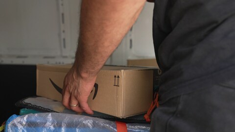 Ein Lieferant hält ein Paket. (Foto: SWR)
