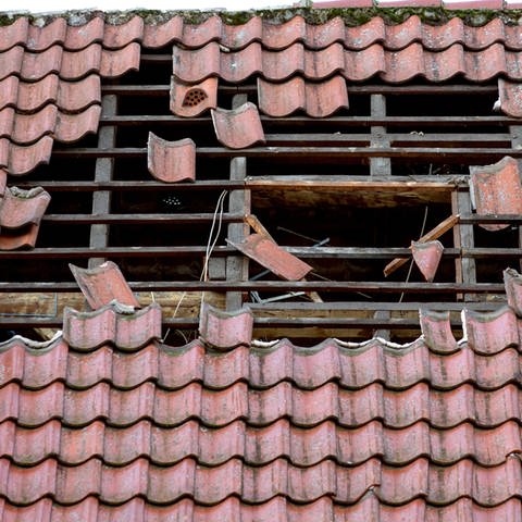 Durch Sturm beschädigtes Dach: Nach einem Unwetter können Dachziegel zur tödlichen Gefahr werden. (Foto: dpa Bildfunk, Friso Gentsch/dpa )
