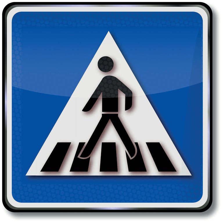 Auf einem blauen Schild ist ein weißes Dreieck abgebildet. Auf diesem Dreieck überquert ein schwarzer Mann mehrere schwarze Streifen. Es handelt sich um das Schild, das einen Fußgängerüberweg ausweist, umgangssprachlich auch Zebrastreifen genannt.
