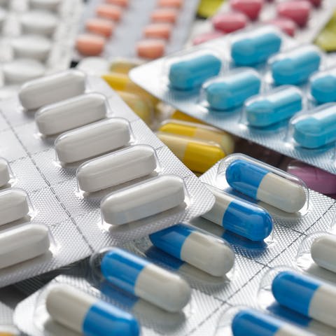 Verschiedene Blister mit weißen und bunten Tabletten und Kapseln liegen auf einem Tisch. Helfen Probiotika wirklich der Gesundheit? (Foto: Colourbox, Colourbox6724640)