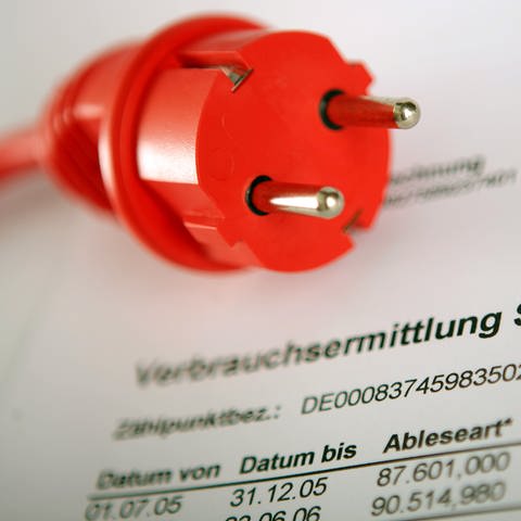 Ein roter Stromstecker liegt auf einer Jahresabrechung für Strom: Post vom Stromanbieter: Ab 1. Juli wird Strom günstiger, weil die EEG-Umlage wegfällt. Das Schreiben unbedingt bis zum Ende lesen. (Foto: dpa Bildfunk, Picture Alliance)