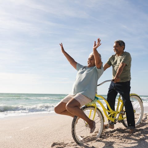 Senioren am Strand mit einem Fahrrade und sehr guter Laune (Foto: picture-alliance / Reportdienste, picture alliance / Zoonar | Channel Partners)