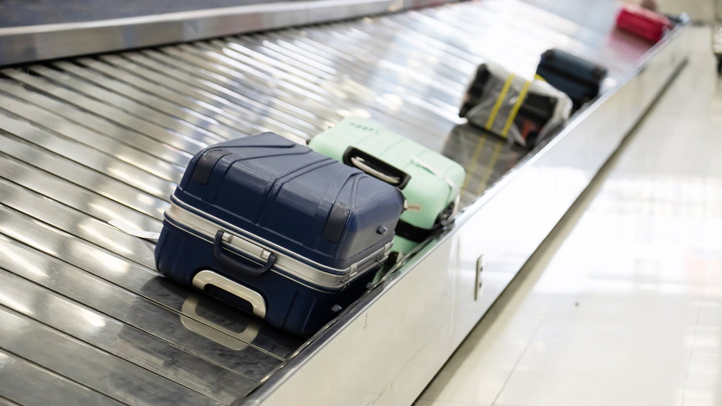 Koffer liegen auf einem Gepäckband am Flughafen. Welche Rechte haben Flugpassagiere, wenn ihr Gepäck nicht ankommt, verspätet ankommt oder beschädigt ist? (Foto: Adobe Stock / momolelouch)
