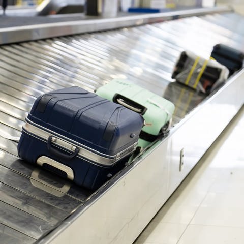Koffer liegen auf einem Gepäckband am Flughafen. Welche Rechte haben Flugpassagiere, wenn ihr Gepäck nicht ankommt, verspätet ankommt oder beschädigt ist? (Foto: Adobe Stock / momolelouch)