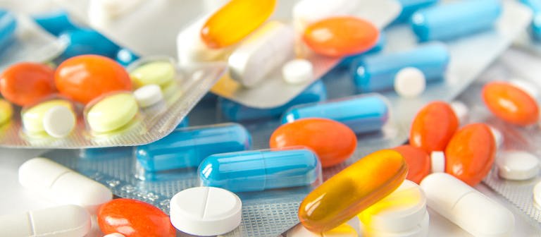Mehrere verschiedene Pillen auf einem Tisch. Aufpassen bei Schmerzmitteln! Sie können Nebenwirkungen verursachen. Ibuflam, Voltaren, ASS, Diclofenac, Thomapyrin  (Foto: Colourbox, #228088)