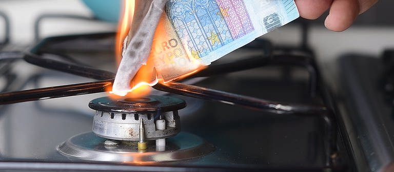 Hand hält brennende Euro-Geldscheine an Gasflamme. Welche Rechte haben Verbraucher angesichts steigender Gas- und Strompreise gegenüber den Versorgern? (Foto: Colourbox)