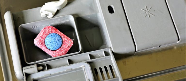 Ein Spülmaschinentab liegt im Fach einer Spülmaschine (Foto: Colourbox)