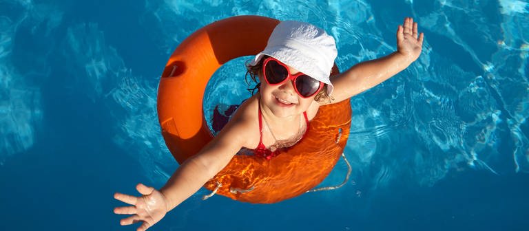 Kind in einem Schwimmreifen mit Hut und Sonnenbrille (Foto: Colourbox, SWR)