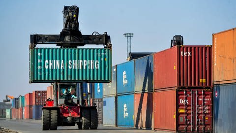 Ein Mann rangiert Container aus China für die Weiterverladung in einer Logistikstation. (Foto: dpa Bildfunk, picture alliance/dpa/XinHua | Lian Zhen)
