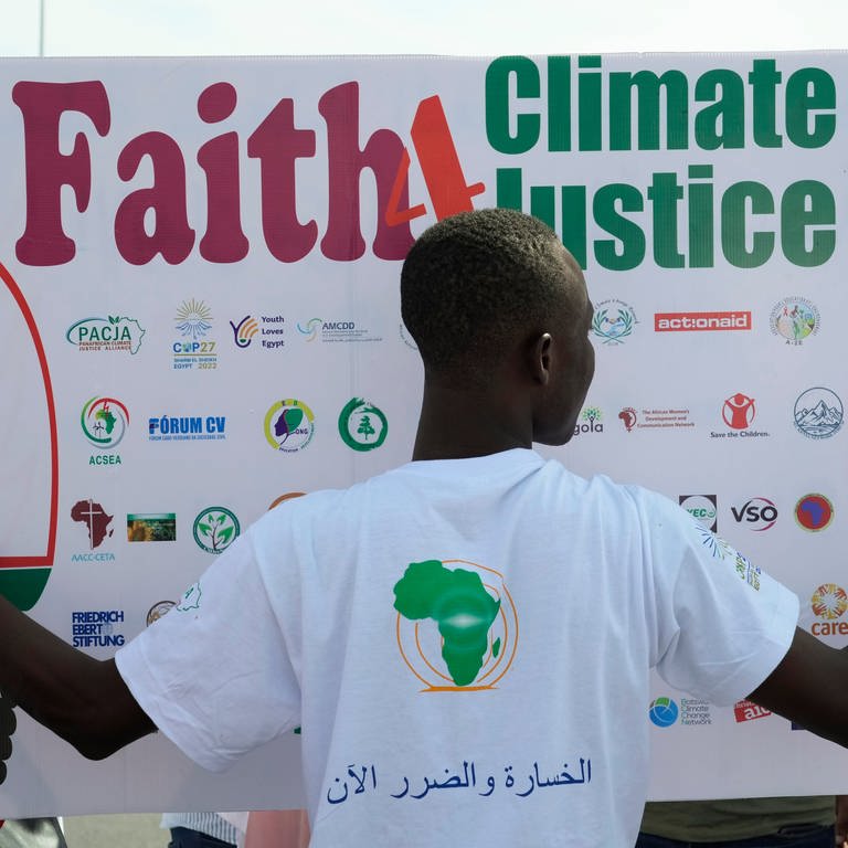 Ein Mann hält ein Plakat während einer Demonstration, bei der zu Klimaschutzmaßnahmen auf dem afrikanischen Kontinent aufgerufen wird. Die Klimakonferenz COP27 findet vom 6. November bis 18. November 2022 in Scharm El-Scheich, Ägypten statt. (Foto: dpa Bildfunk, Picture Alliance)