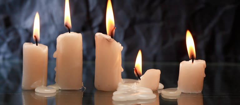 Kerzen brennen und Wachs fließt auf den Tisch: Wachsflecken entfernen - mit Kälte oder mit Wärme? (Foto: Colourbox)