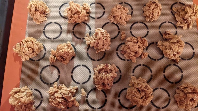 Schmackhafte Haferflocken-Plätzchen, die zur Adventszeit mit Lebkuchengewürz verfeinert werden können. Die Haferflocken-Plätzchen liegen auf einer Backmatte. (Foto: SWR)