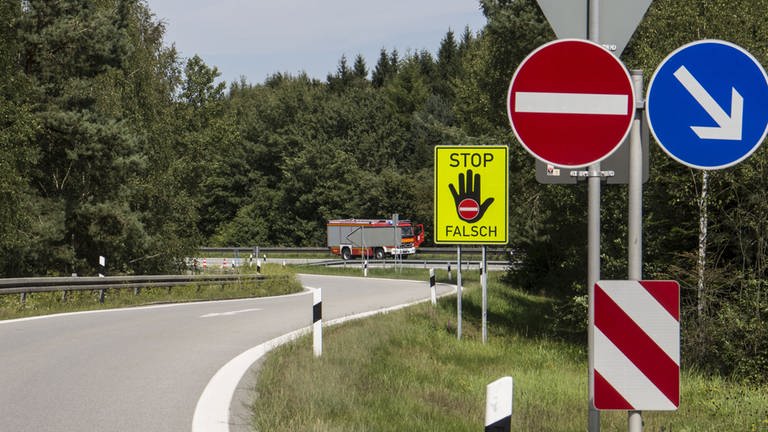 Grelgelbe Warntafeln mit schwarzer Hand und Stoppschild warnen an einer Autobahnausfahrt davor, sie als Auffahrt zu benutzen (Foto: dpa Bildfunk, Picture Alliance)