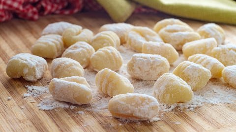 Schritt-für-Schritt Grundrezept, wie man Gnocchi ganz einfach selber machen kann mit einer cremigen Käse-Soße. Nahaufnahme von  frischen und in Mehl panierten Gnocchi. (Foto: Adobe Stock/ Ezume Images)