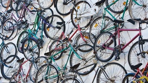 An der Wand hängen viele Fahrräder. (Foto: dpa Bildfunk, Picture Alliance)